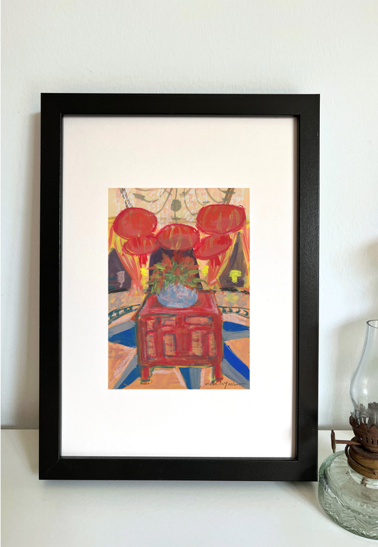 Framed painting of decorative interior of 32 Mansion Penang with red lanterns, a vase with flowers, and a red cabinet on a colourful background.