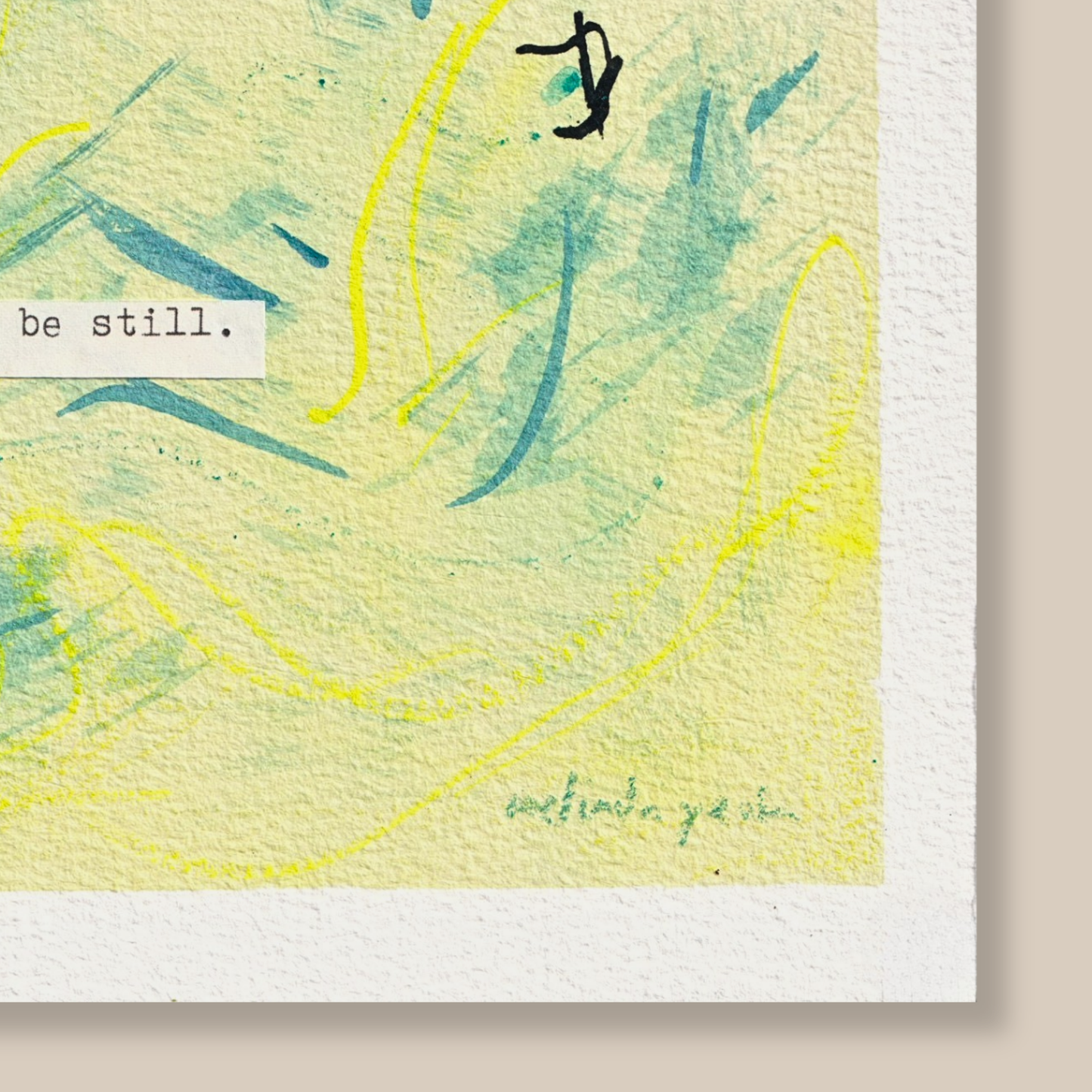 Close up of bstract mixed media painting with typewritten text 'be still' on textured cold pressed watercolour paper on a beige background