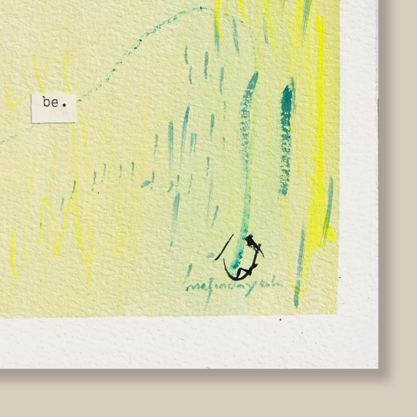 Close up of abstract mixed media painting with typewritten text 'be' on textured cold pressed watercolour paper on a beige background