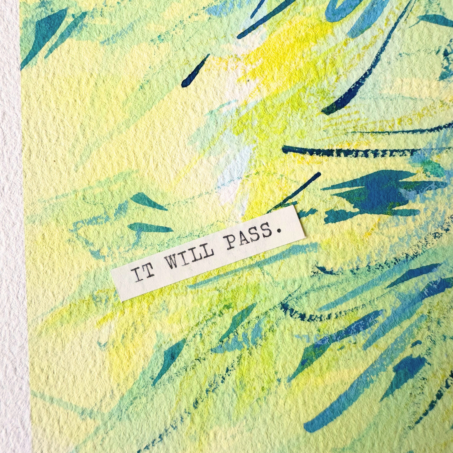 Close up of abstract mixed media painting with typewritten text 'It Will Pass' on a textured cold-pressed watercolour paper