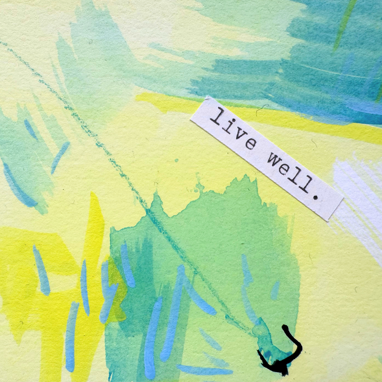 Close up of abstract mixed media painting with typewritten text 'Live Well' on a smooth hot-pressed watercolour paper on a beige background