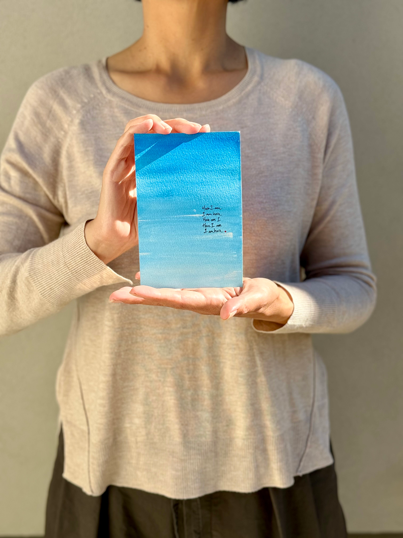 image: artist holding an abstract painting