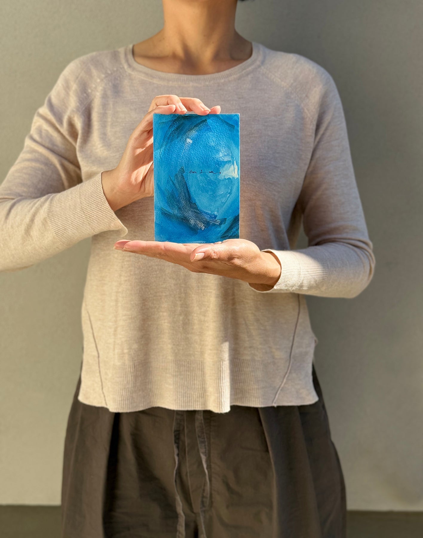 image: artist holding an abstract painting