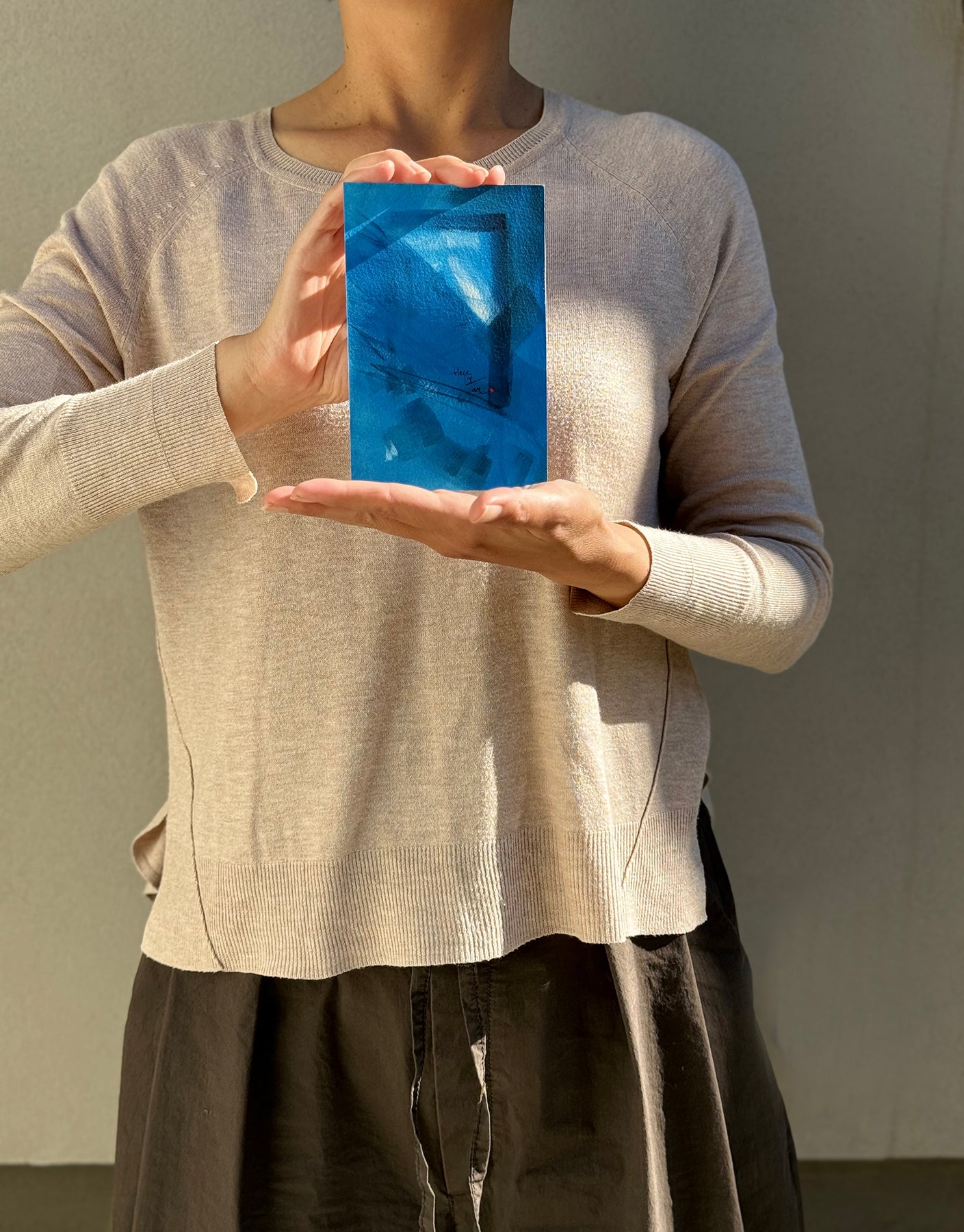 image: artist holding an abstract painting