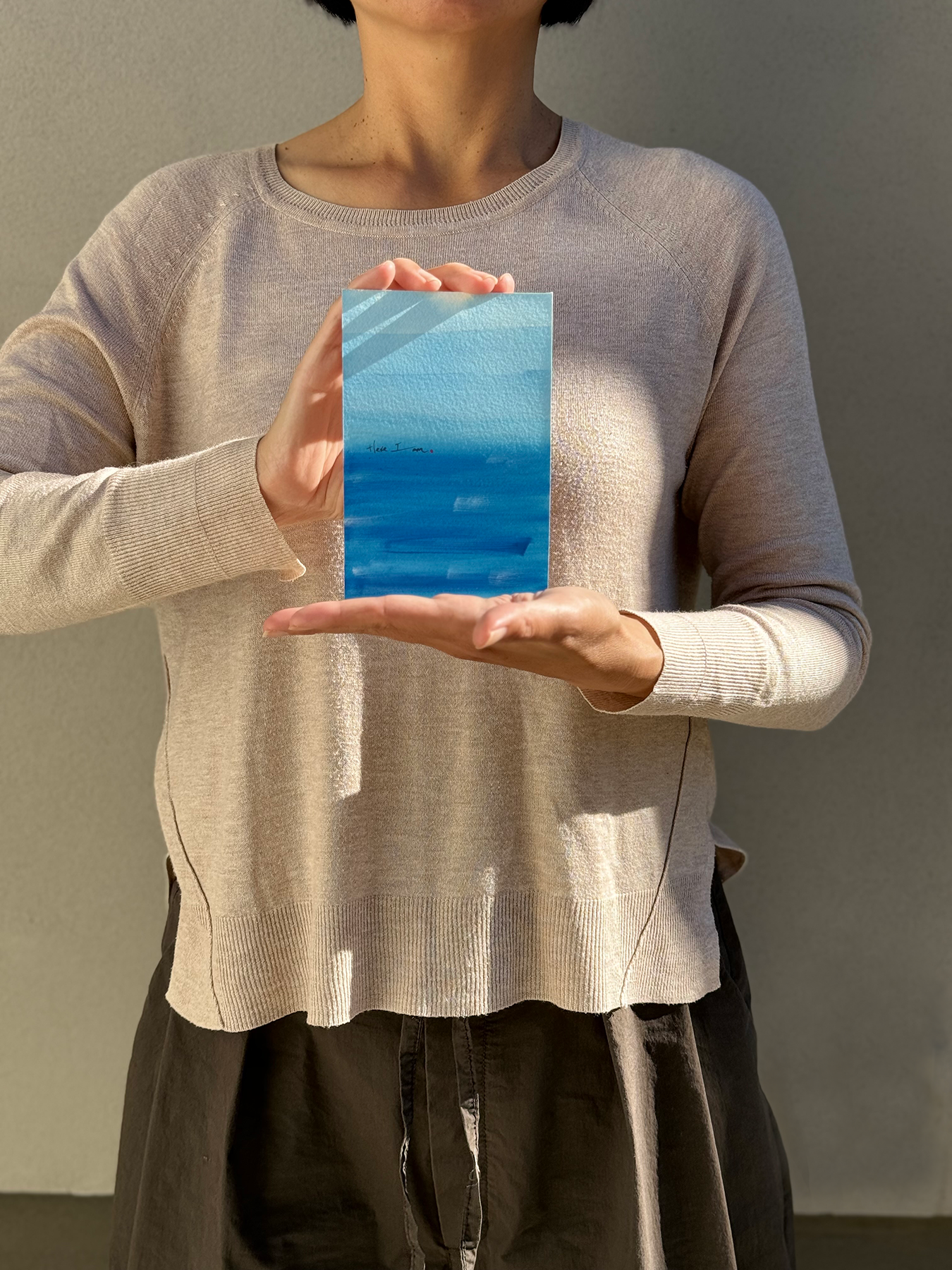 image: artist holding an abstract painting blue 