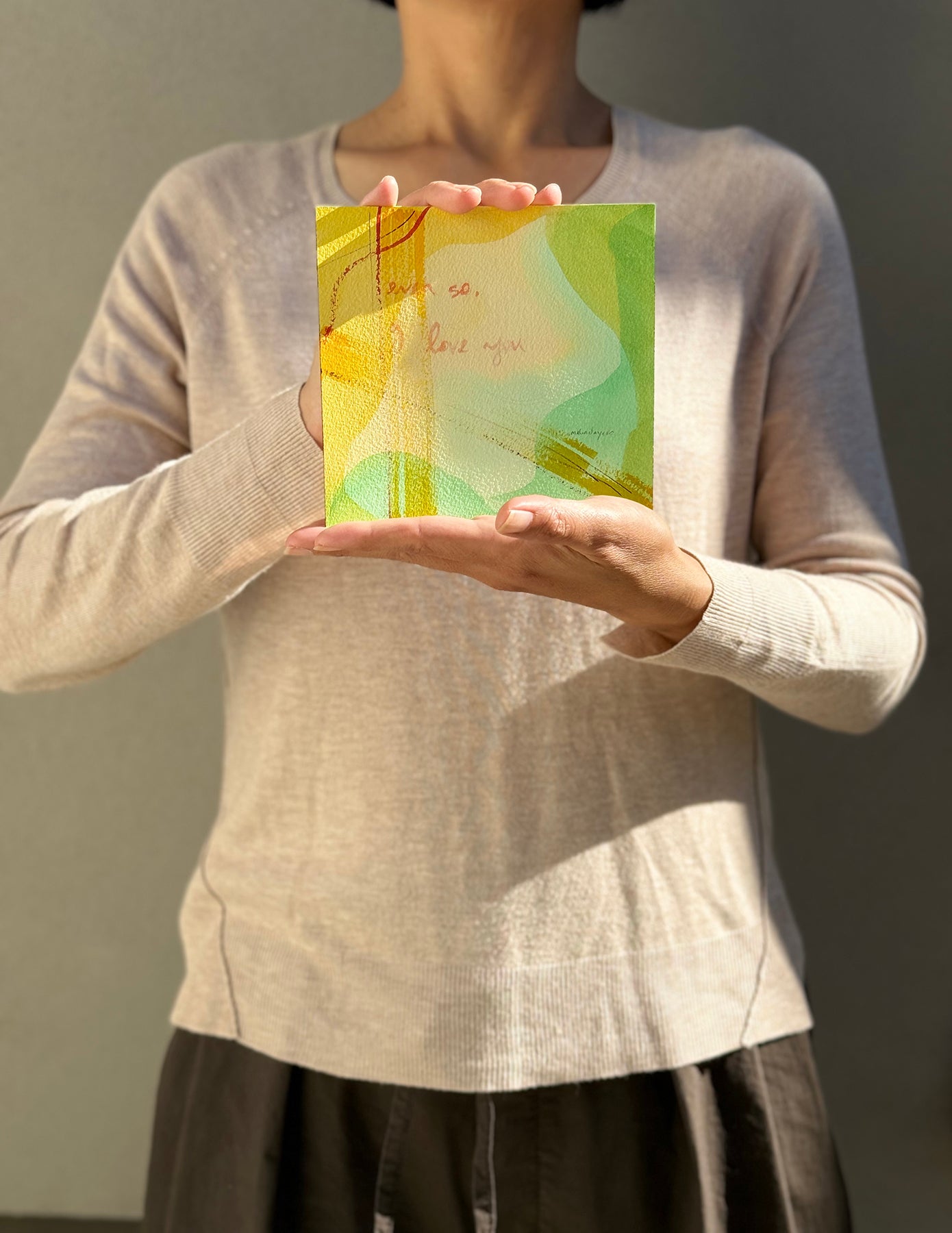 image: artist holding an abstract painting