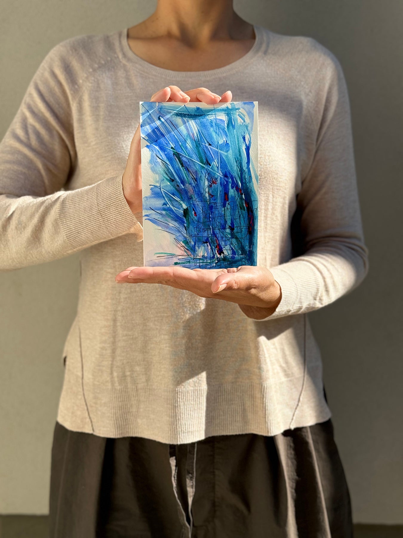 image: artist holding an abstract painting