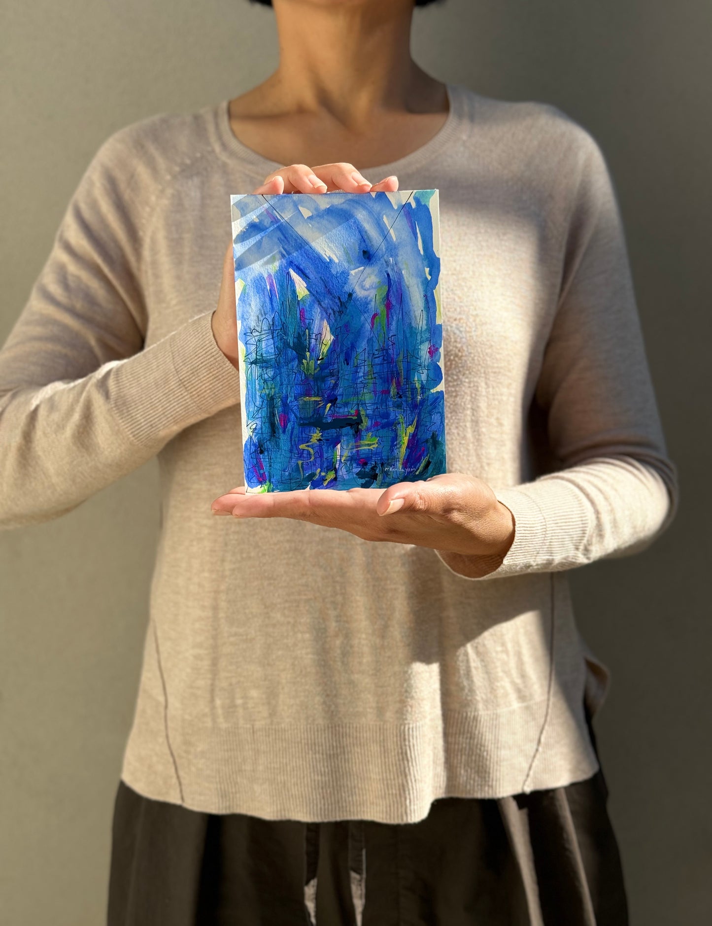 image: artist holding an abstract painting