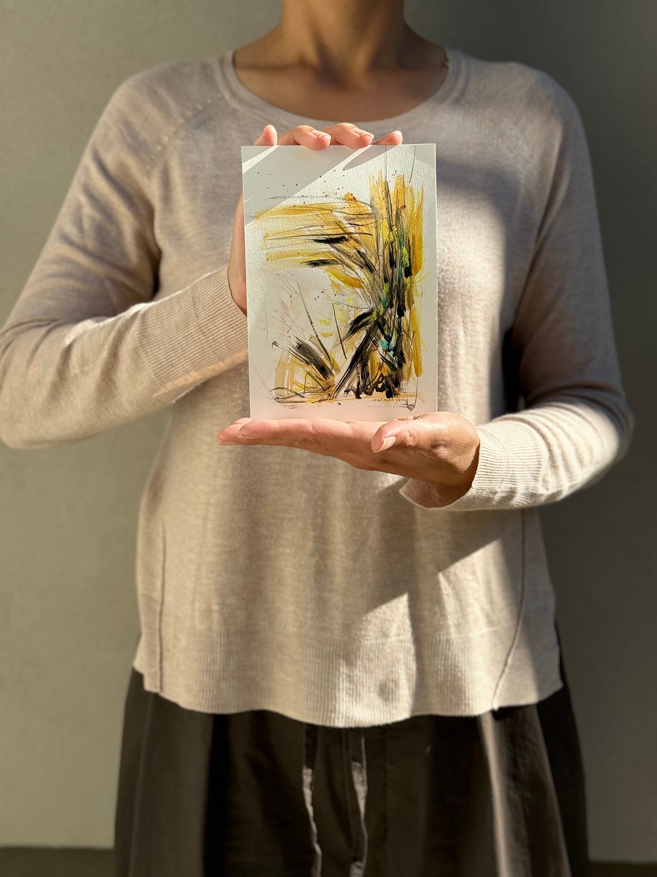 image: artist holding an abstract painting