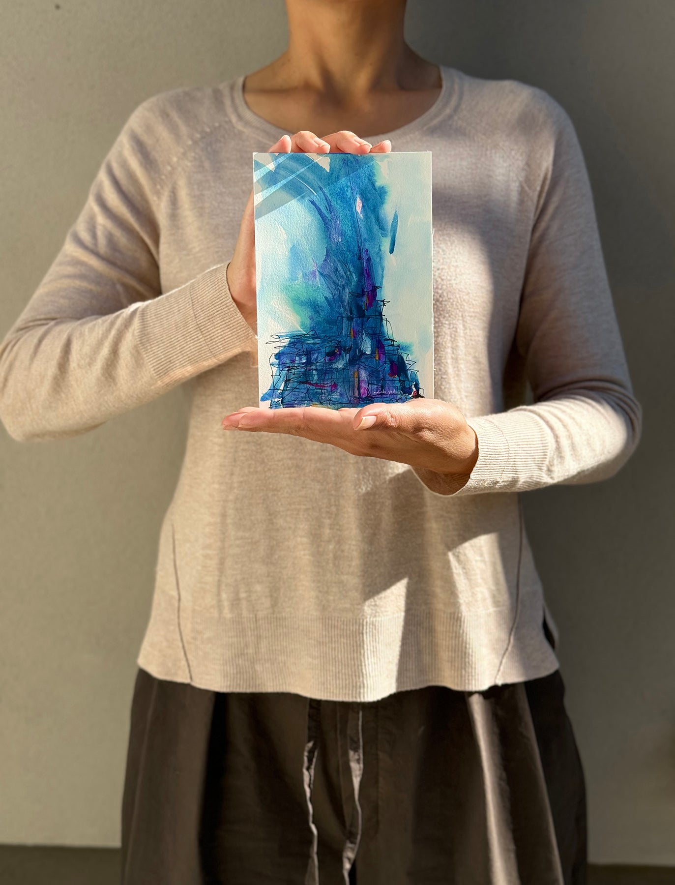 image: artist holding an abstract painting