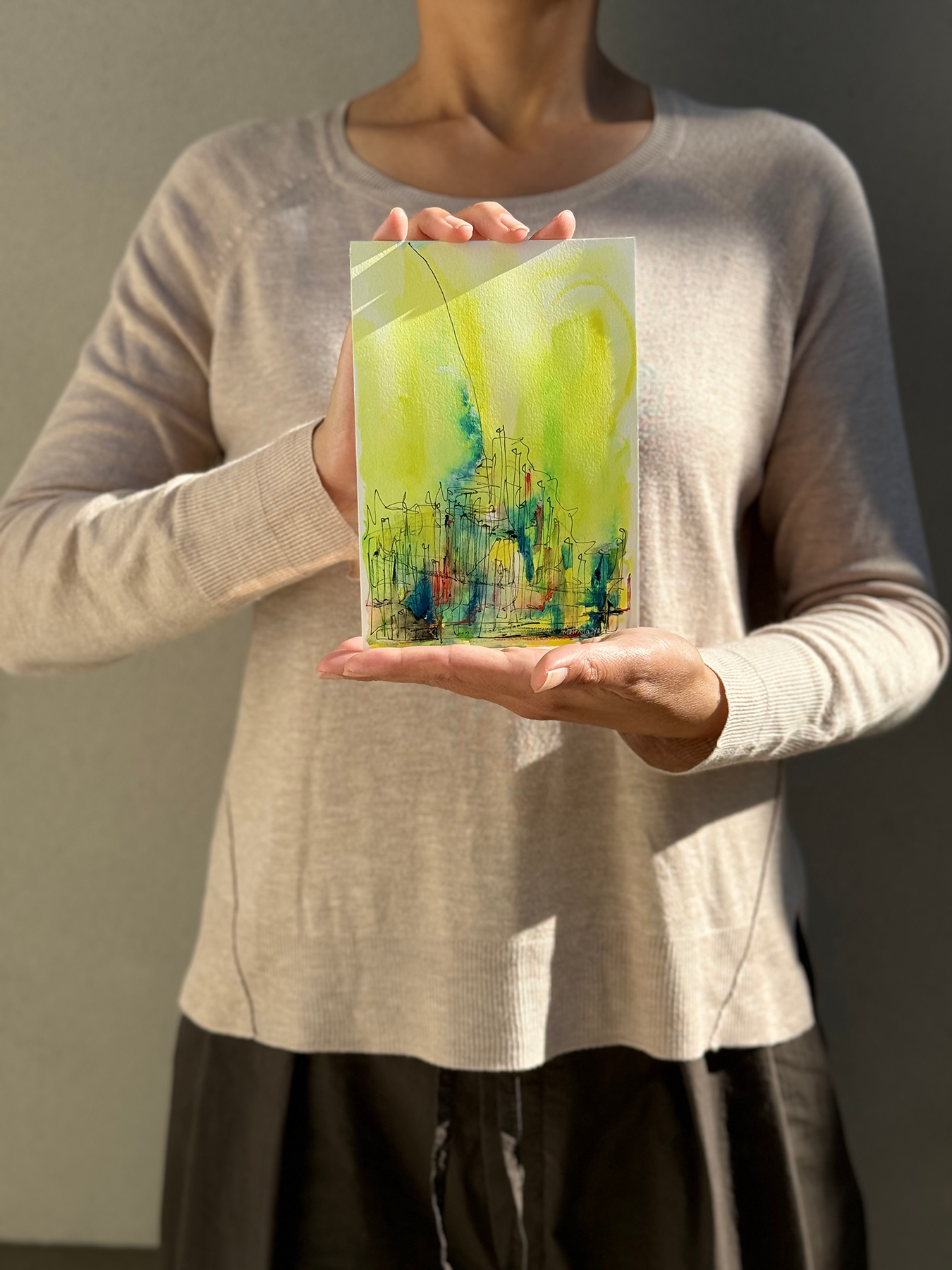 image: artist holding an abstract painting