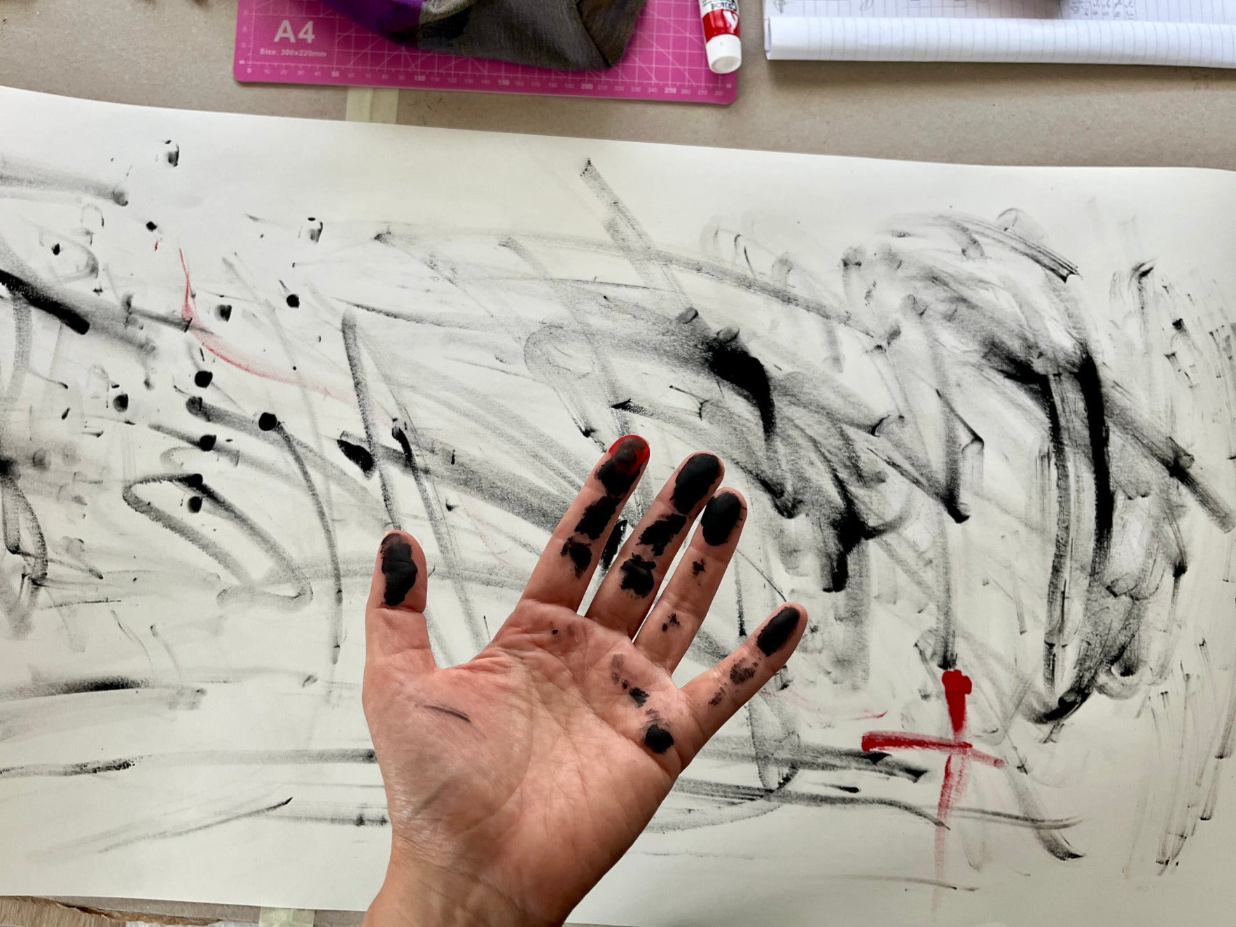 Hand with black paint splashes on a paper with abstract black and white brush strokes by Melinda Yeoh Art from monologue\worship/conversations series