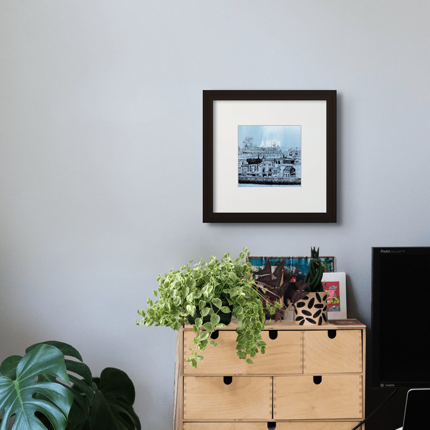 6” x 6” giclée art print with black frame and cream colour mat, in a home office setting. Scenery of Gaia, with old buildings and cable car, seen from Riberia, Porto, Portugal, in line drawing with watercolour. 