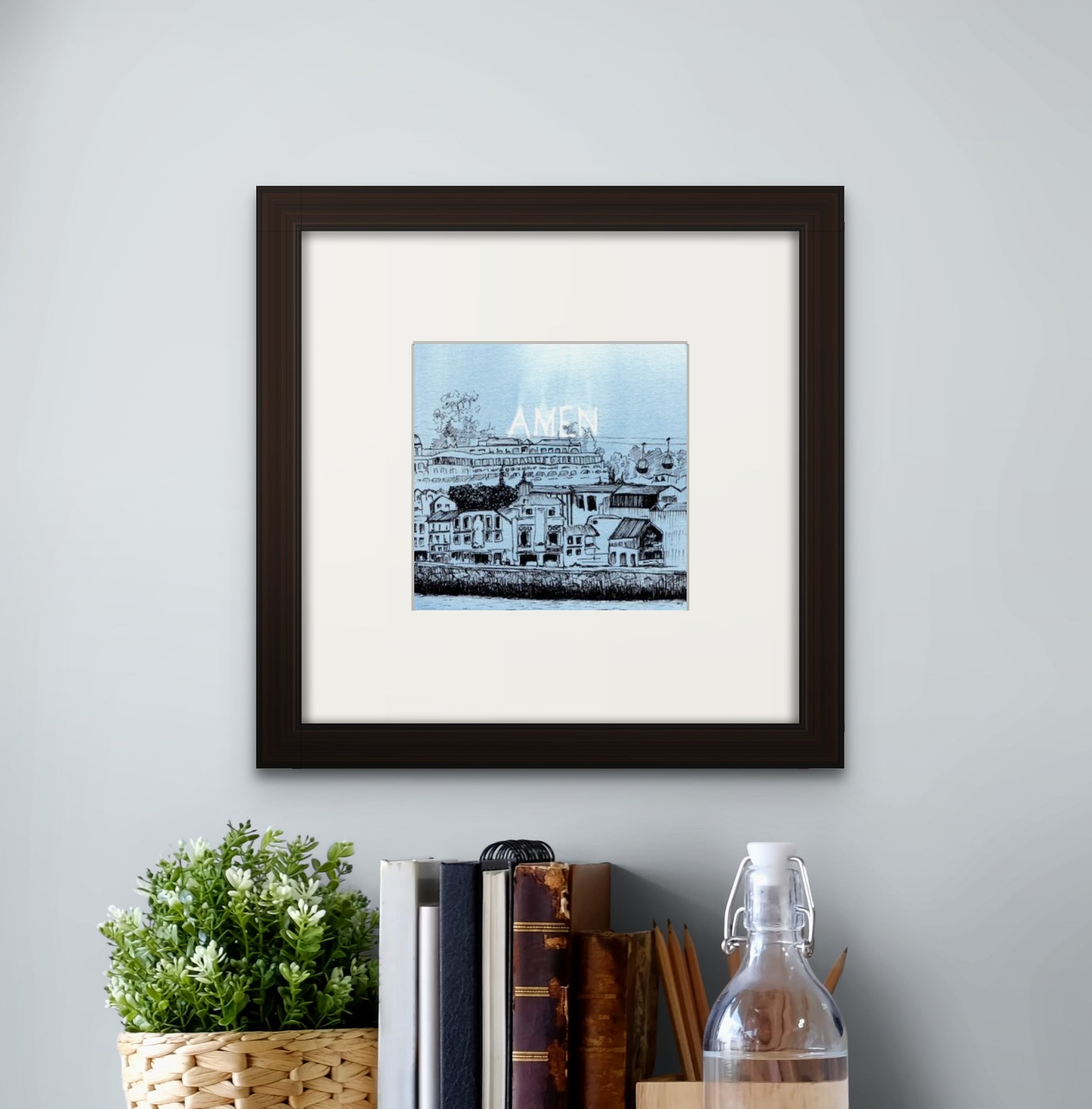 6” x 6” giclée art print with black frame and cream colour mat, hung above a work desk table top. Scenery of Gaia, with old buildings and cable car, seen from Riberia, Porto, Portugal, in line drawing with watercolour. 
